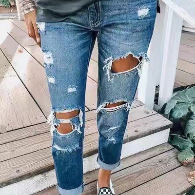 Blue ripped jeans for women with distressed detailing and a mid-waist design