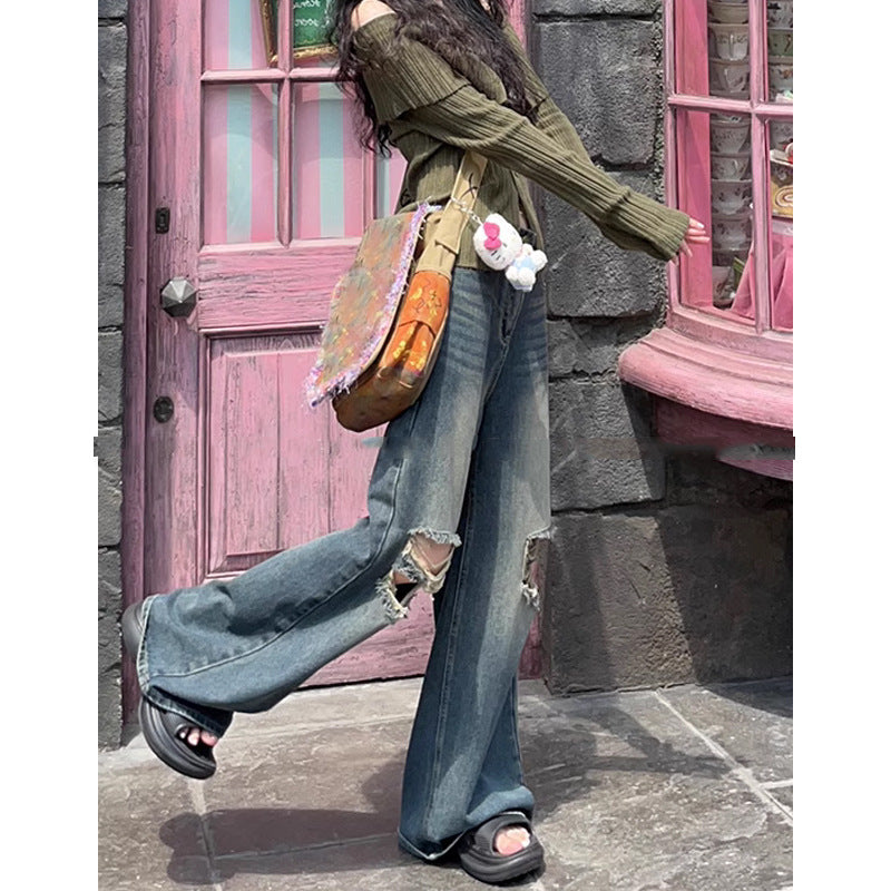 Woman wearing blue retro washed ripped jeans with straight legs and micro elasticity outdoors near pink door