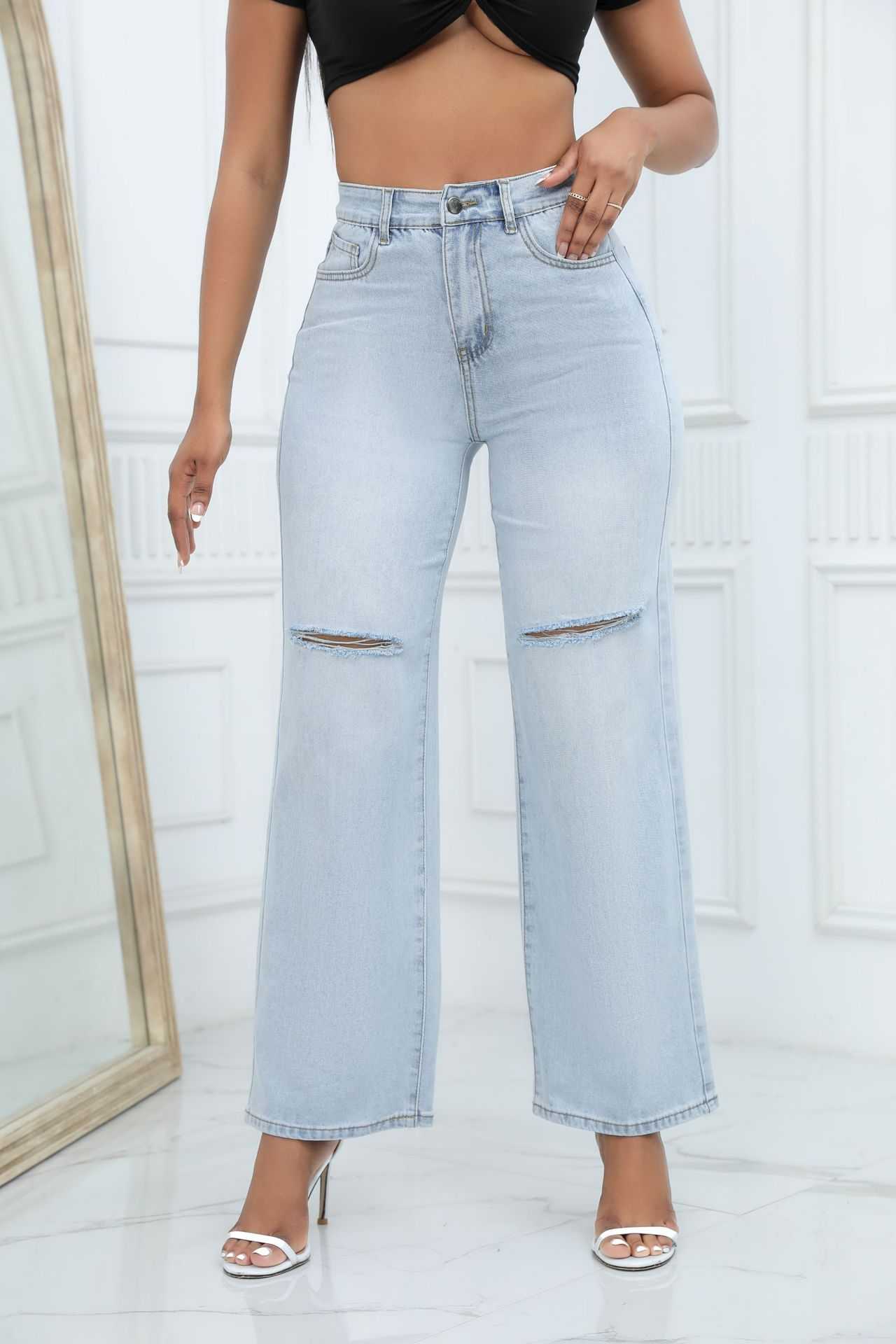 Light blue elegant ripped wide-leg jeans for women with mid waist and straight-leg design.