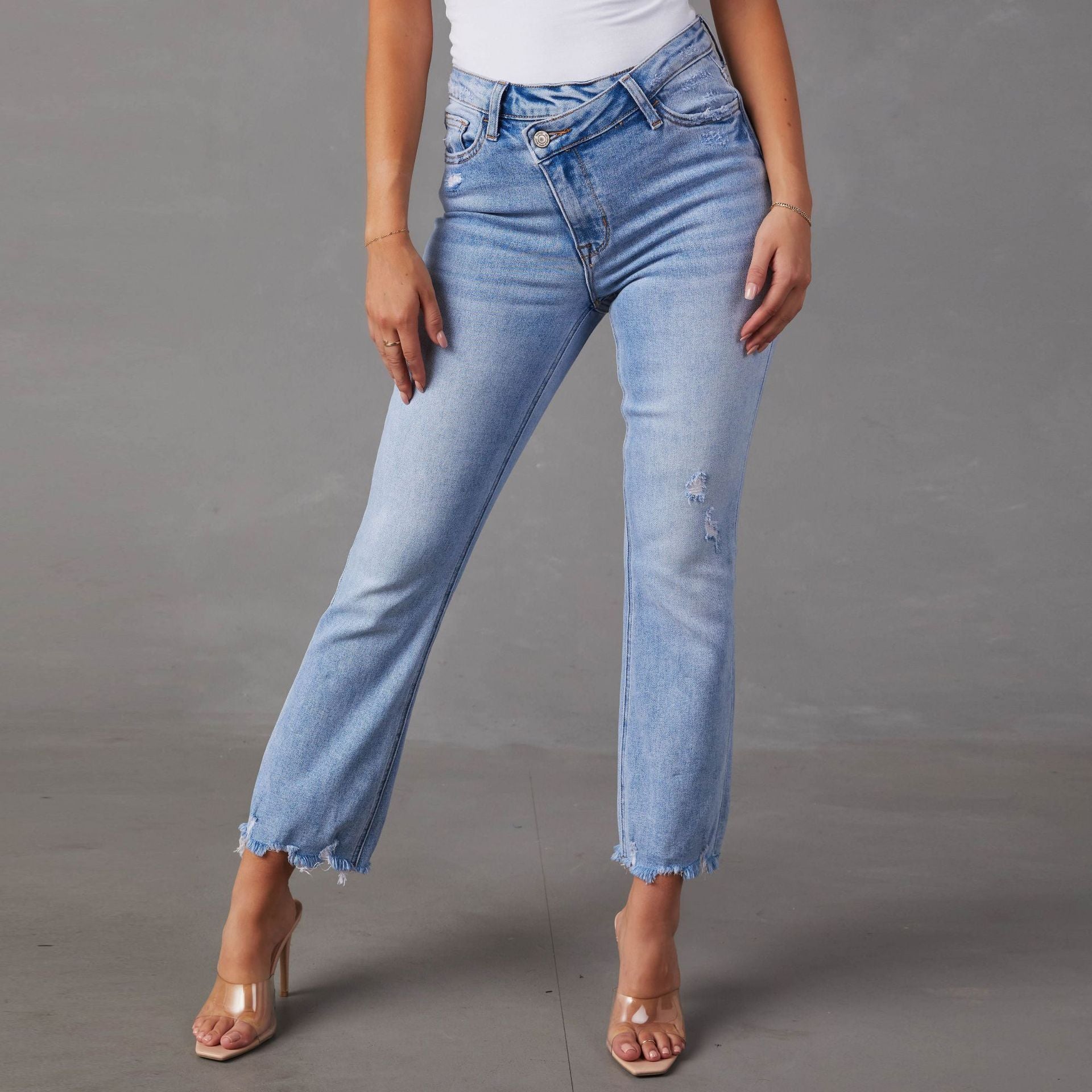 Light blue fashion wash jeans for women with distressed holes and frayed hems in European American style
