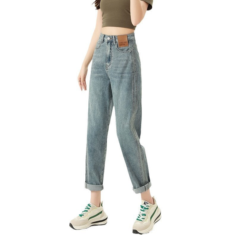 Woman wearing retro blue high waist straight harem jeans with rolled cuffs and sneakers